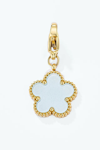 Gold-tone flower charm with a pale blue enamel centre and a beaded edge, on a clip clasp