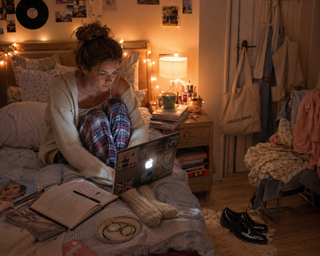 A teenage girl watching a move on her mac