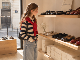 A teen looking a shoes in a shop