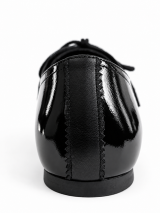 Back view of a black soft crinkled patent Maévie Oxford Ballet flat, showing the heel, the matte leather back strip with zigzag stitching and the low heel