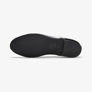 Underside of a black Maévie Oxford Ballet flat, showing the black sole with an embossed logo